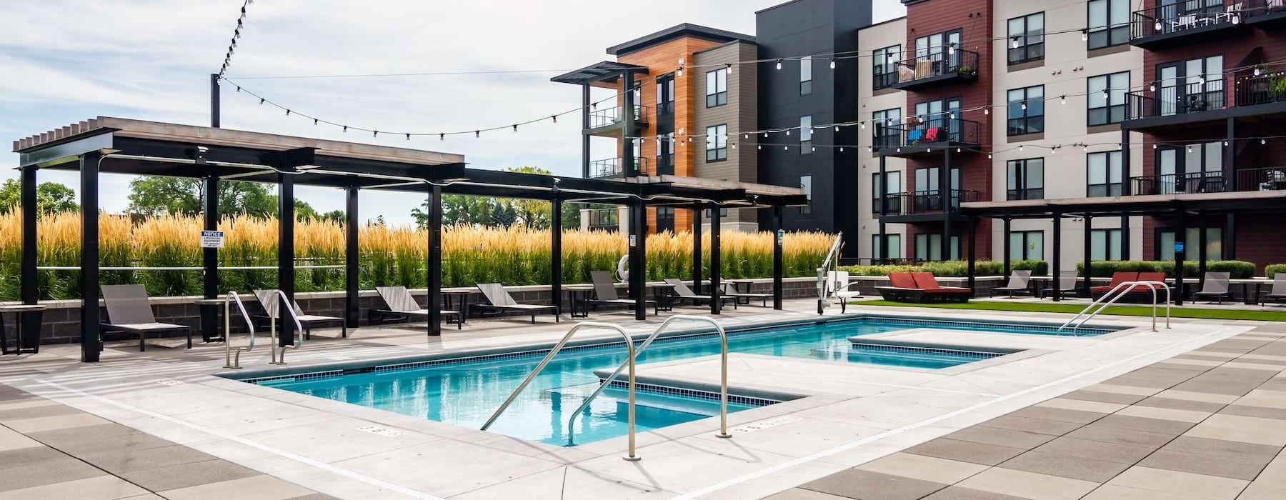 a swimming pool in a courtyard with buildings in the background