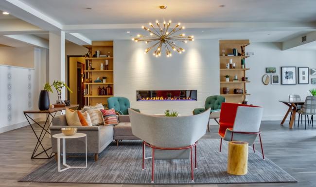 a lounge with a couch, chairs and a fireplace