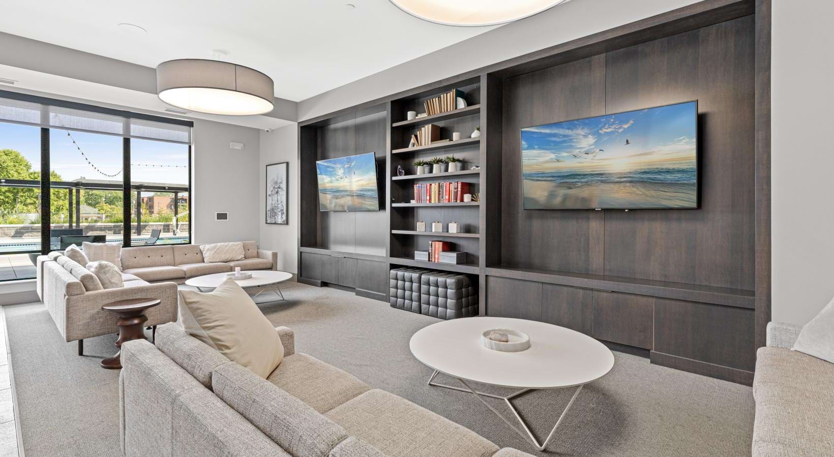 a clubroom with couches, tables and tv's